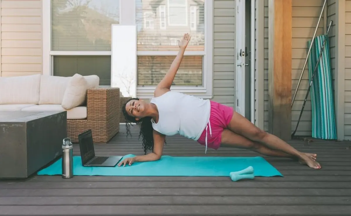 woman working out on a deck making side plank