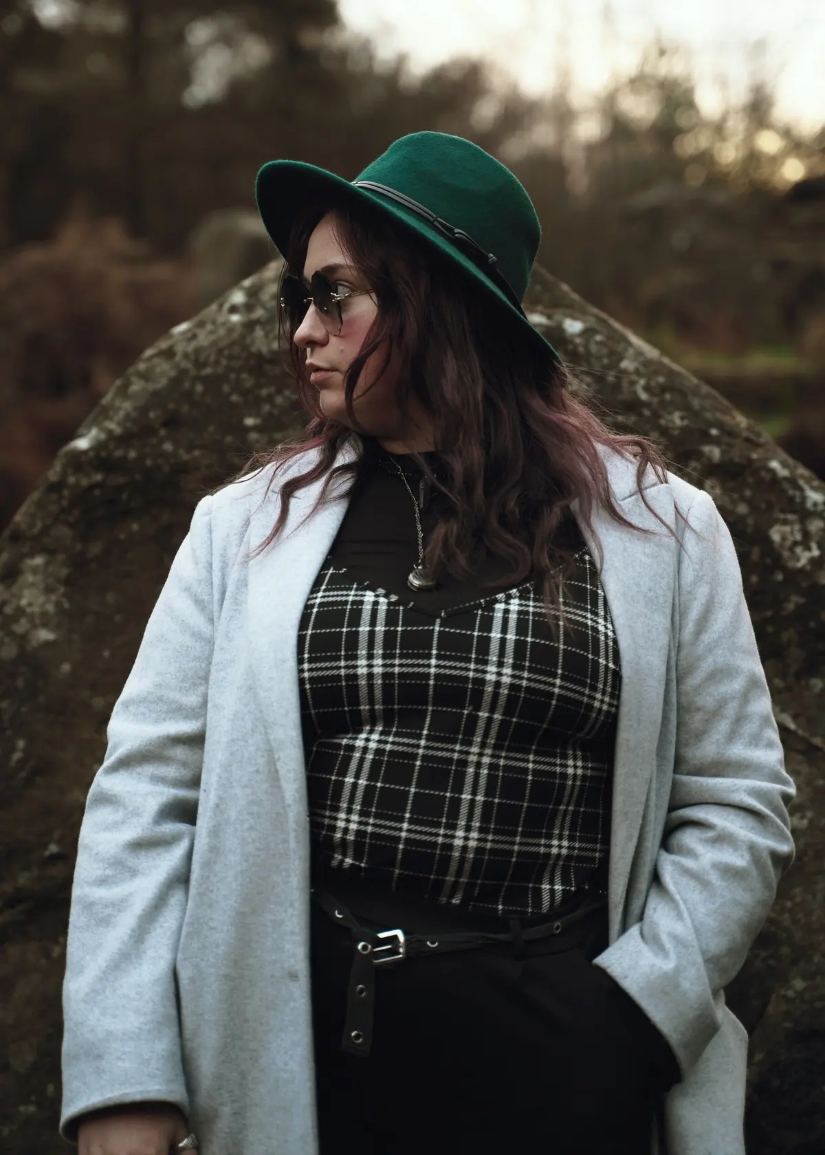 plus size model autumn outfit with black and white checkered top, light grey coat and green hat