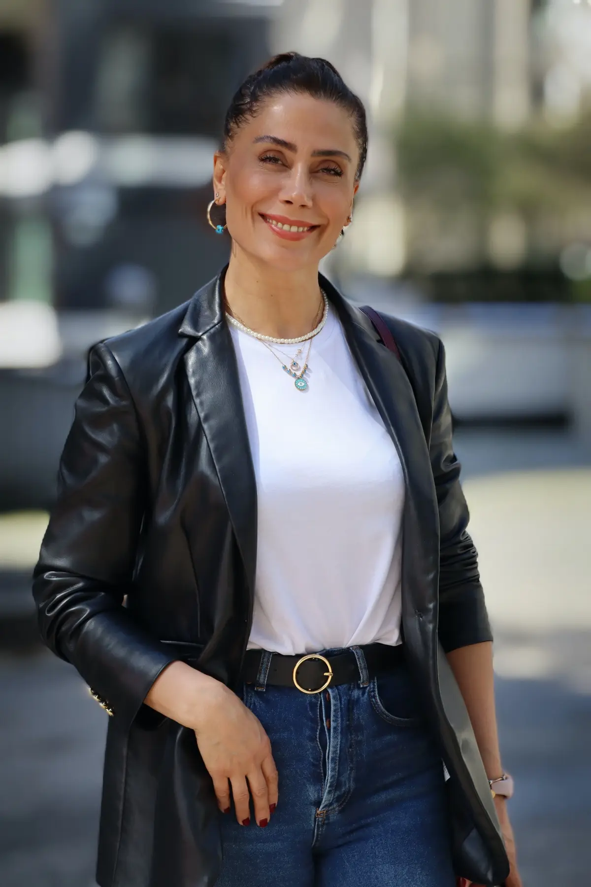 woman wearing black leather blazer paired with white top and jeans