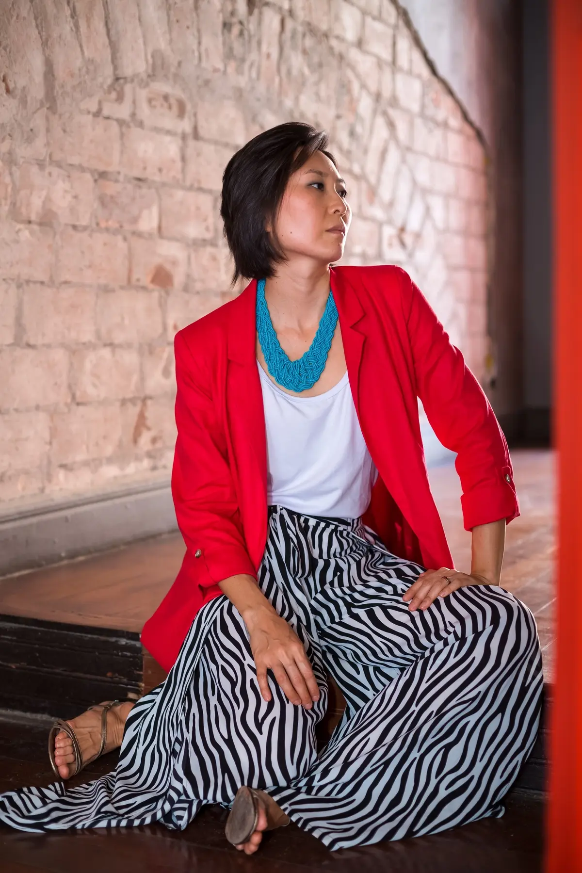 zebra patterned trousers paired with white top and red blazer