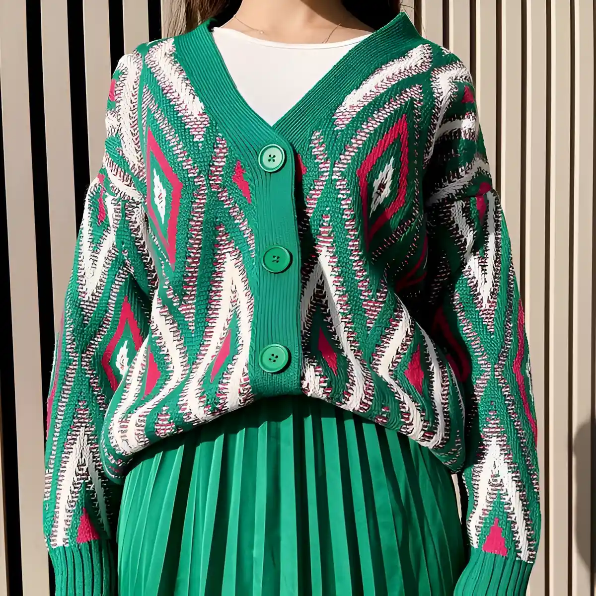 green pleated skirt paired with patterned oversized cardigan in same color