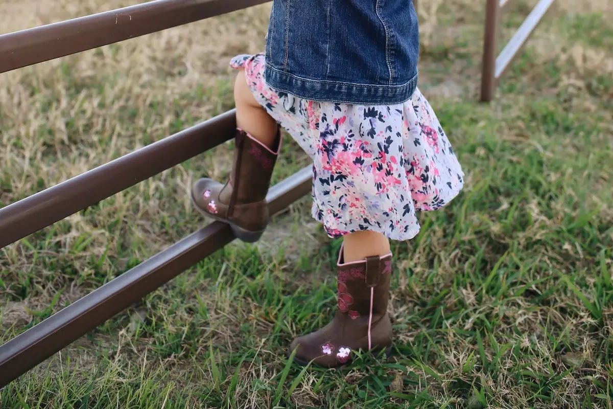 kids cowgirl boots paired with floral skirt and denim jacket