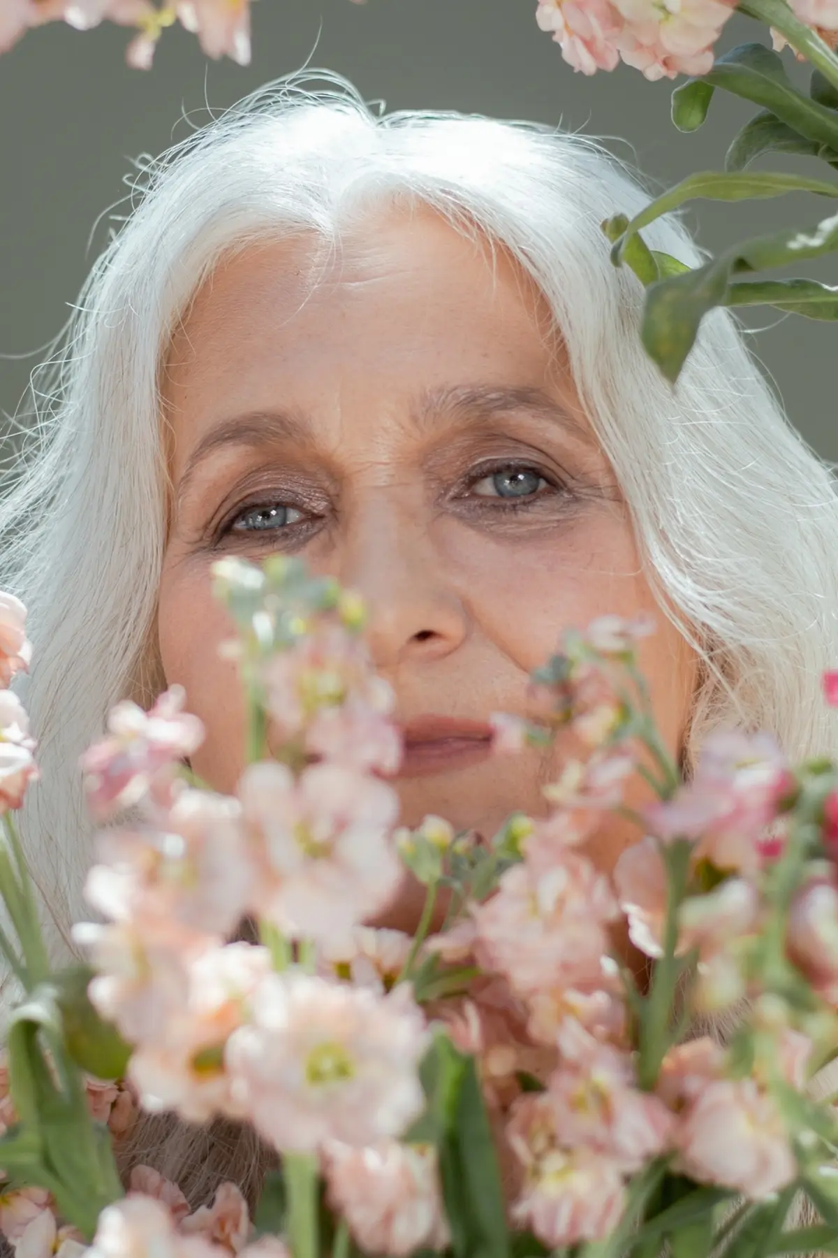 mature woman with blue eyes and white hair and subtle makeup