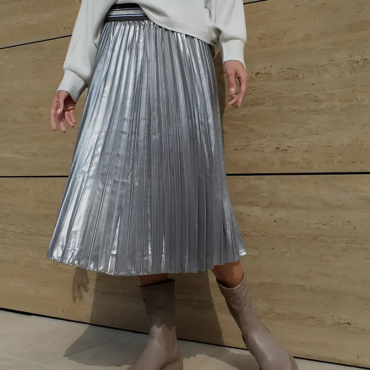 metallic silver pleated skirt paired with white sweater and beige boots