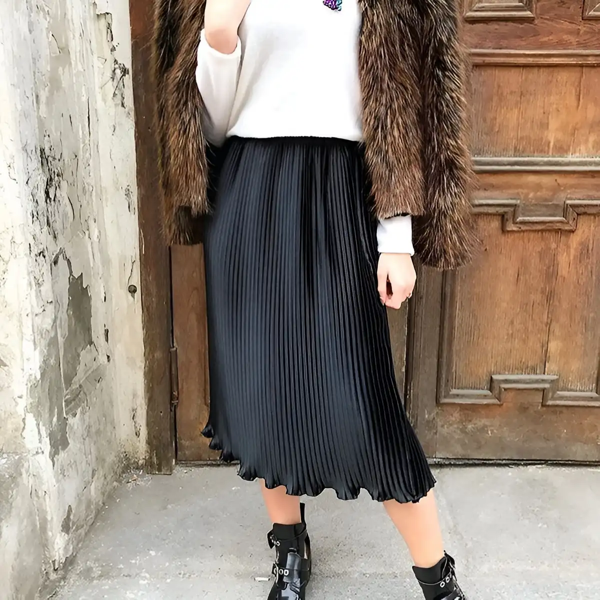midi black skirt paired with cream sweater and fur coat