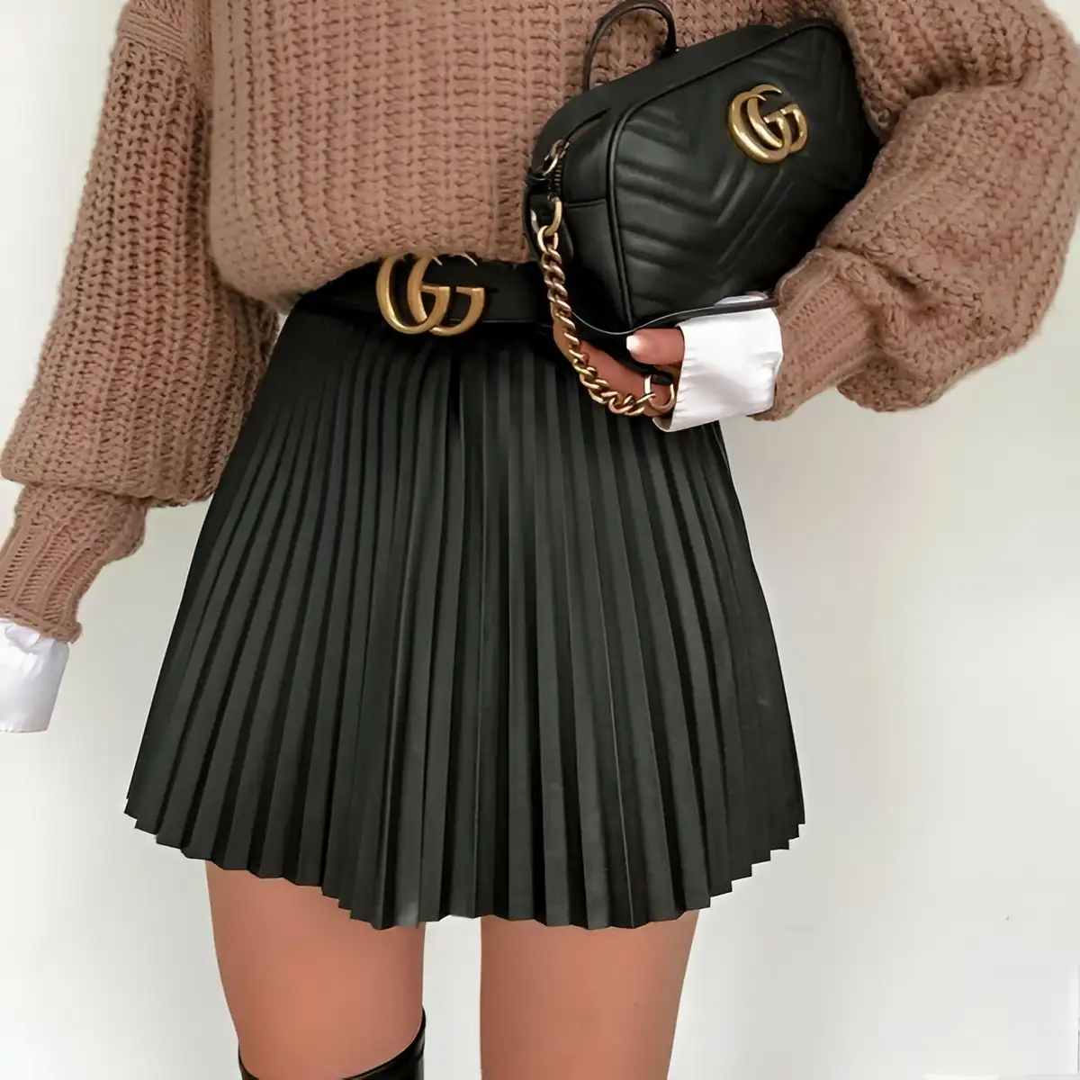 mini leather black pleated skirt paired with oversized chunky knit brown sweater and white shirt
