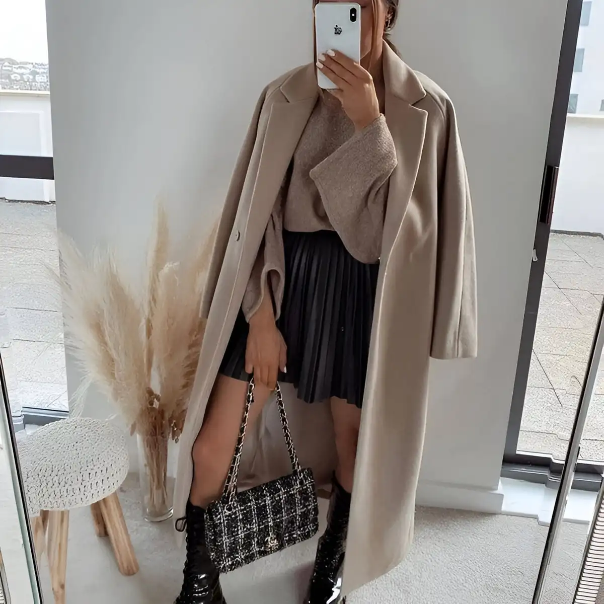 mini leather pleated skirt paired with boots beige sweater and coat