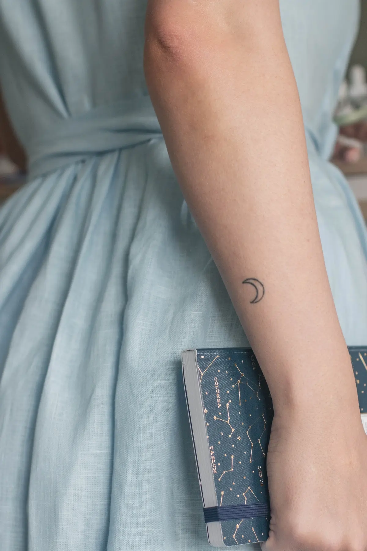 minimalist crescent moon tattoo on wrist
