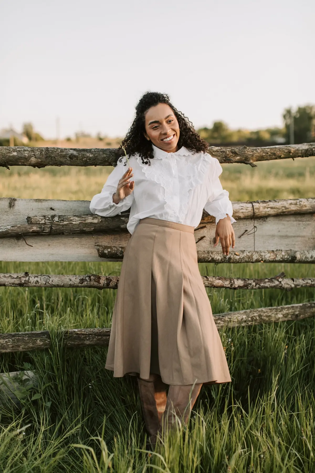beige midi skirt paired with brouse with ruffles and boots