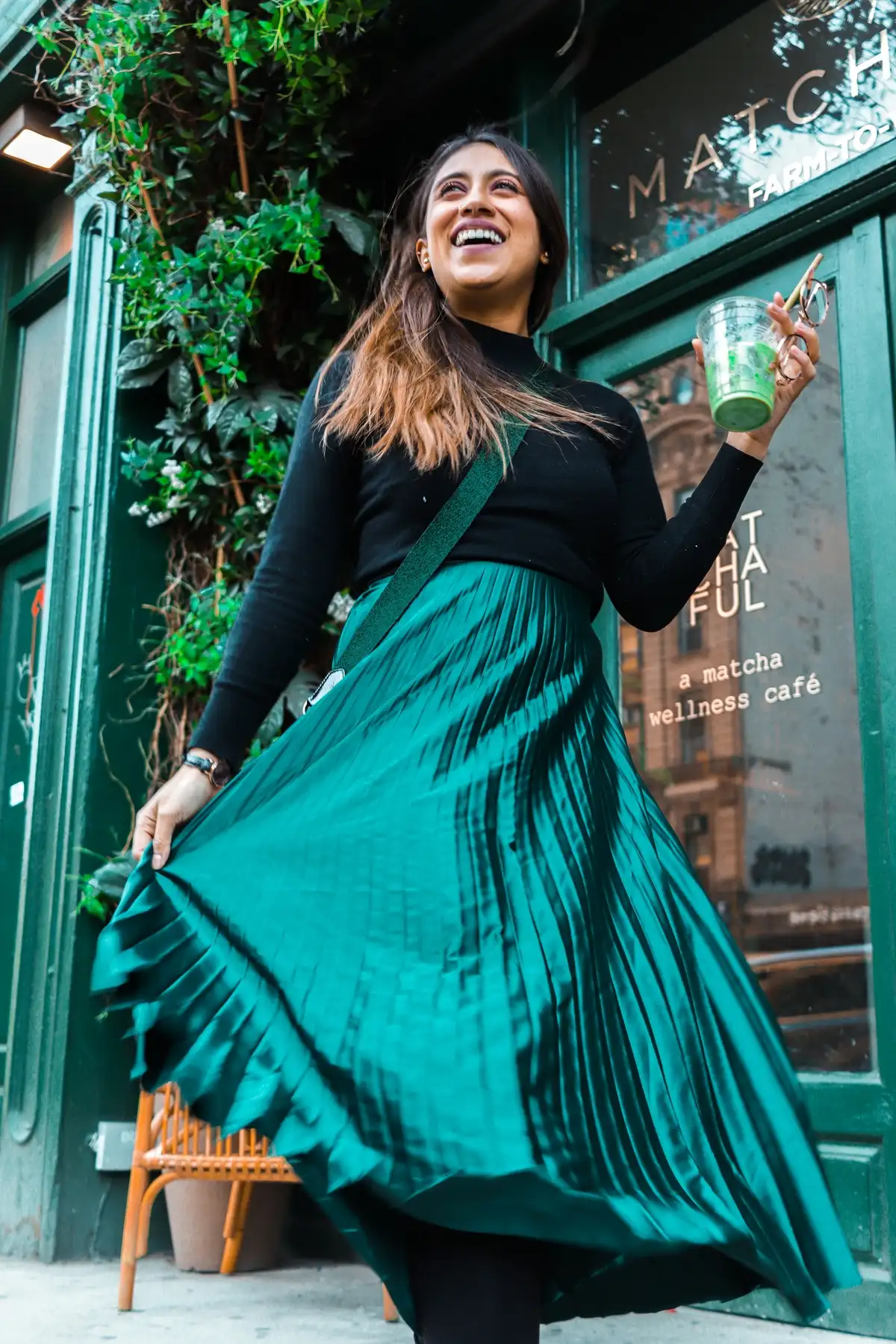 long emerald green pleated skirt paired with black long sleeved top